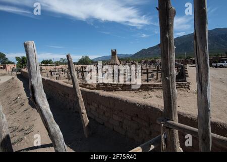 Der historische Taos Pueblo Friedhof in New Mexico mit verwitterten Holzkreuzen, die die Gräber der indianischen Gemeinde markieren. Stockfoto