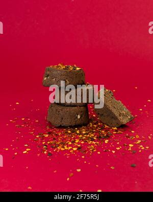 Mexikanische Brownies mit Paprika auf rotem Hintergrund. Kohlenhydratarme Keto-Dessert mit Kokosmehl. Stockfoto
