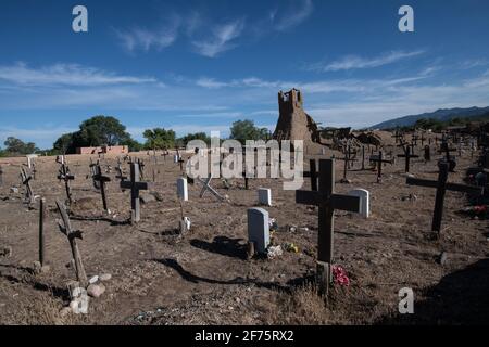 Der historische Taos Pueblo Friedhof in New Mexico mit verwitterten Holzkreuzen, die die Gräber der indianischen Gemeinde markieren. Stockfoto