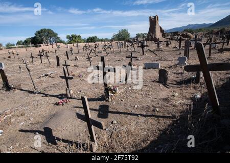 Der historische Taos Pueblo Friedhof in New Mexico mit verwitterten Holzkreuzen, die die Gräber der indianischen Gemeinde markieren. Stockfoto