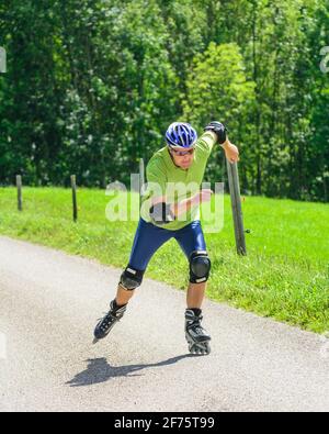 Mann eine skating Tour auf Inline Skates in der grünen Natur Stockfoto