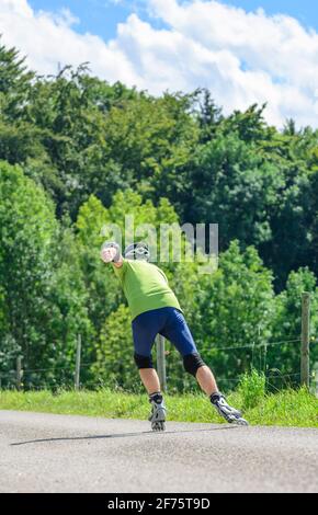 Mann eine skating Tour auf Inline Skates in der grünen Natur Stockfoto