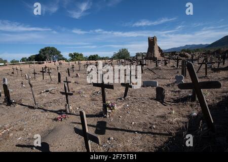 Der historische Taos Pueblo Friedhof in New Mexico mit verwitterten Holzkreuzen, die die Gräber der indianischen Gemeinde markieren. Stockfoto