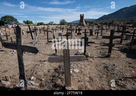 Der historische Taos Pueblo Friedhof in New Mexico mit verwitterten Holzkreuzen, die die Gräber der indianischen Gemeinde markieren. Stockfoto