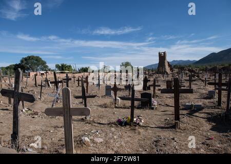 Der historische Taos Pueblo Friedhof in New Mexico mit verwitterten Holzkreuzen, die die Gräber der indianischen Gemeinde markieren. Stockfoto