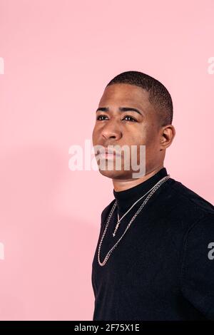 Stock Foto von jungen schwarzen Mann posiert im Studio vor rosa Hintergrund geschossen. Stockfoto
