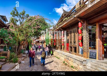 Shuhe Naxi, China - 28. April 2019: Menschen, die in der Hauptstraße des antiken Dorfes Shuhe Naxi spazieren. Dieses Dorf ist eines der am besten erhaltenen Stockfoto