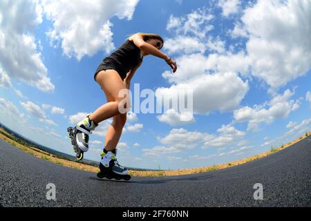 Teenager Mädchen auf Rollschuhe im Sommer. Inline-Skating auf der Straße. Stockfoto