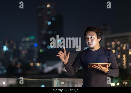 Kreativer Freiberufler aus Asien mit Technologie-Tablet und lächelnd im Finanzdistrikt an der bangkok River Side, Thailand, Business Technolog Stockfoto