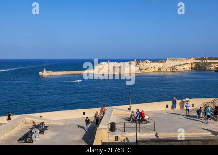Menschen auf der Terrasse am Meer in Valletta und Fort Ricasoli in Kalkara, Malta Stockfoto
