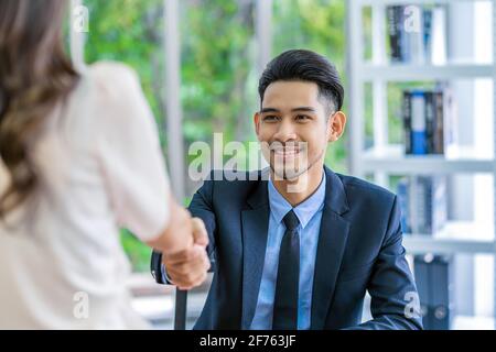 Nahaufnahme Handshake nach Interview Vereinbarung zwischen Young Asian Frau und zwei Manager mit positiver Bewegung im Besprechungsraum, Handshake mit Manager, BU Stockfoto