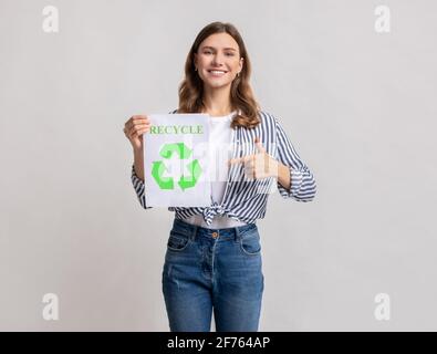 Happy Young Eco-Volunteer Lady Holding-Schild Mit Grünem Recycling-Symbol Mit Pfeilen Stockfoto