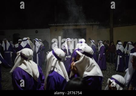 Cucuruchos in lila Gewändern werden feierlich durch die Straßen von Antigua, Guatemala, während der traditionellen Feierlichkeiten der Weihnachtsfeier in der Karwoche Semana gefeiert. Stockfoto