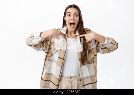 Extrem glücklich und überrascht Frau Gewinnerin zeigt auf sich selbst, feiern und schauen aufgeregt, gewinnen oder ausgewählt werden, bekam Job, gegen stehen Stockfoto