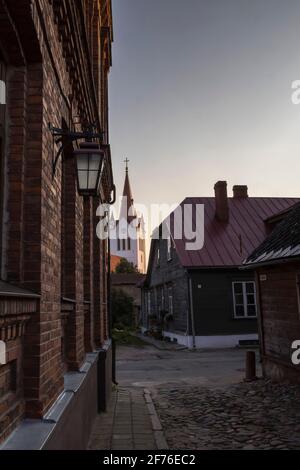 Leere Kopfsteinpflasterstraßen und Kirchturm in der Kleinstadt Cesis. Stockfoto