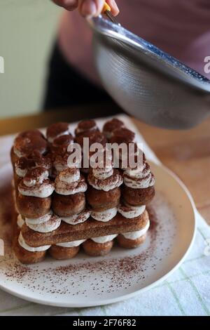 Tiramisu, italienisches Dessert. Frau bereitet Tiramisu-Kuchen vor. Nahaufnahme. Stockfoto