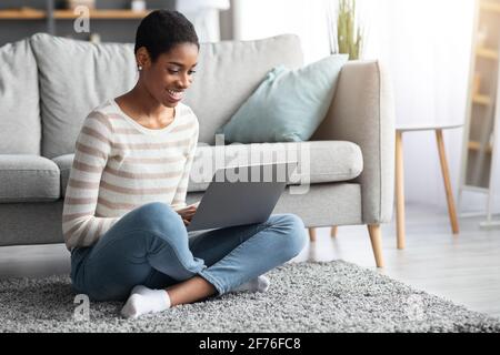 Remote-Arbeit. Lächelnde Schwarze Freiberufliche Frau, Die Zu Hause Mit Einem Laptop Arbeitet Stockfoto