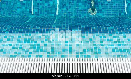 Blick von oben auf den leeren Whirlpool im Swimmingpool mit blauen Mosaikfliesen und Abflussstangen. Transparente ruhige Pool Wasser Hintergrund für Foto-Collage. Glatte ENT