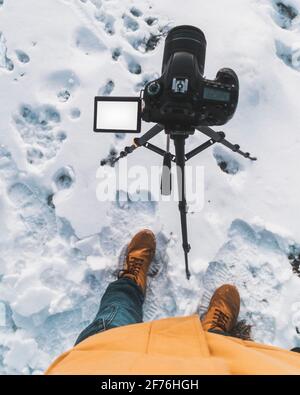 Blogger Fotograf Winter Zeit kopieren Raum Bildschirm Kamera Stativ Fußabdrücke Im Schnee Stockfoto
