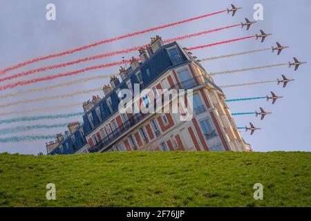 Paris, Frankreich - 07 17 2019: Flugschau vom 14. Juli. AlphaJET der Patrouille von Frankreich, die hinter einem Gebäude fliegt Stockfoto