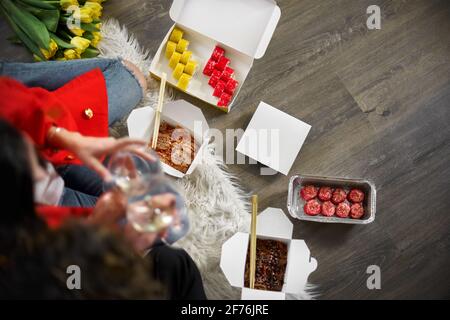 Draufsicht auf ein junges Paar, das Sushi isst. Konzept für die Lieferung von Lebensmitteln. Zum Mitnehmen Stockfoto