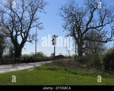 Die Buckelbrücke auf der Banbury Lane, über dem Northampton Arm des Grand Union Canal, wird durch eine Ampel gesteuert, um den einspurigen Verkehr zu steuern. Stockfoto