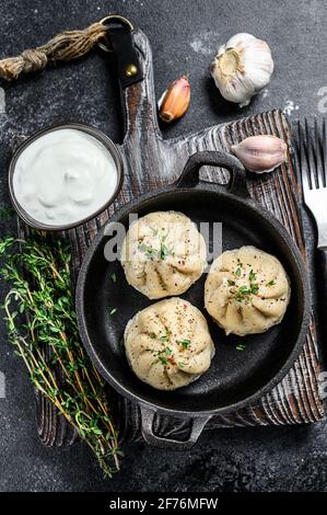 Asiatische gedünstete Knödel Manti in einer Pfanne. Schwarzer Hintergrund. Draufsicht Stockfoto