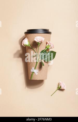 Wiederverwendbare Öko-Kaffee- oder Teetasse mit Rosenzweig auf beigem Hintergrund. Nachhaltiger Lebensstil. Umweltfreundlich und Zero Waste Konzept.Flat Lay Stockfoto