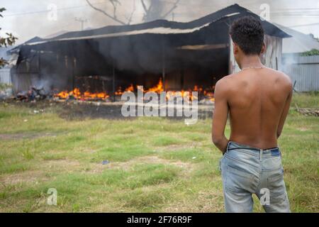 Kendari, Indonesien. April 2021. Ein Bewohner sieht zu, wie das Lagerhaus in Kandari zu Flammen brennt.heute brach ein Feuer aus und verschlang ein Lagerhaus in Kendari. Augenzeugen zufolge wurde das Feuer durch einen Stromkurzschluss ausgelöst, der nach dem Auftreffen auf eine Gasflasche und ein Motorrad im Lagerhaus Flammen aufging. (Foto von Andry Denisah/SOPA Images/Sipa USA) Quelle: SIPA USA/Alamy Live News Stockfoto