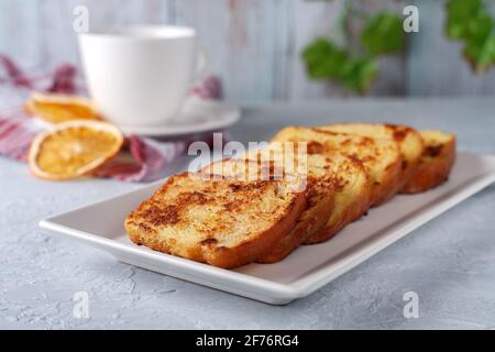Französischer Toast mit Tee auf grauem Hintergrund. Gesundes Frühstückskonzept. Stockfoto