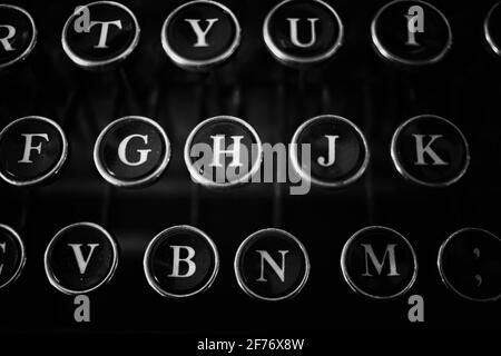 Nahaufnahme der antiken Schreibmaschinentasten mit deutlich abgebildeten Buchstaben. In Schwarz-Weiß fotografiert. Stockfoto