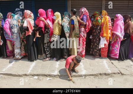 Frauen versammeln sich in einer Schlange, um Reis und Mehl vom Open Market Sale (OMS) in Modu Shohid, Sylhet, zu kaufen. Eine landesweite Sperrung wurde für 7 Tage verhängt. Bangladesch. Stockfoto