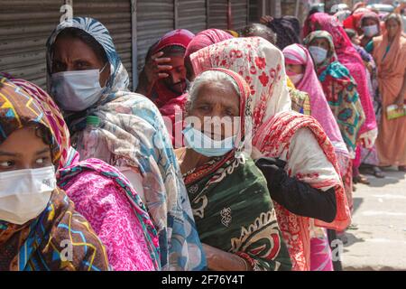 Frauen versammeln sich in einer Schlange, um Reis und Mehl vom Open Market Sale (OMS) in Modu Shohid, Sylhet, zu kaufen. Eine landesweite Sperrung wurde für 7 Tage verhängt. Bangladesch. Stockfoto