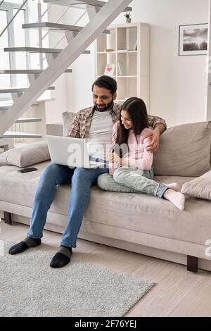 Glücklicher indischer Vater und Teenager-Tochter mit Laptop-Computer zu Hause. Stockfoto