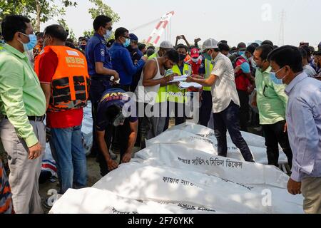 Verwandte und Zuschauer versammeln sich um die Leichen, nachdem sie von dem gekenppten Start im Fluss Shitalakshya in Narayanganj erholt wurden. Die Zahl der Todesopfer durch die Abschusskippe im Fluss Shitalakkhya am Sonntag ist auf 26 gestiegen, nachdem ein Rettungsschiff den Abschuss aus dem Wasser gezogen hat. Am Sonntag gegen 19 Uhr sank das Passagierschiff ml Sabit Al Hasan nach einer Kollision mit dem Frachtschiff SKL-3 an der Mündung des Syedpur Koyla Ghat am Fluss Shitalakkhya in Narayanganj. Stockfoto