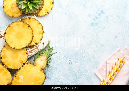 Geschnittene reife Ananas auf hellblauem Stein Hintergrund. Tropische Früchte. Draufsicht. Freier Speicherplatz für Text. Modell. Stockfoto