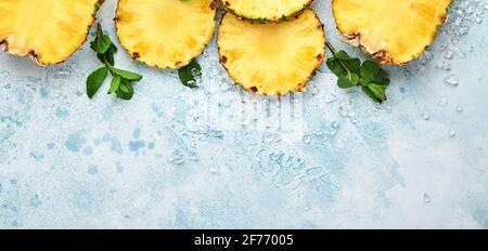 Geschnittene reife Ananas auf hellblauem Stein Hintergrund. Tropische Früchte. Draufsicht. Freier Speicherplatz für Text. Modell. Stockfoto