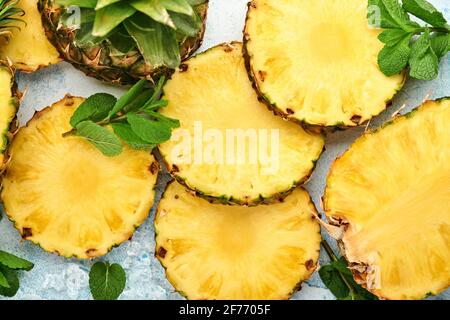 Geschnittene reife Ananas auf hellblauem Stein Hintergrund. Tropische Früchte. Draufsicht. Freier Speicherplatz für Text. Modell. Stockfoto