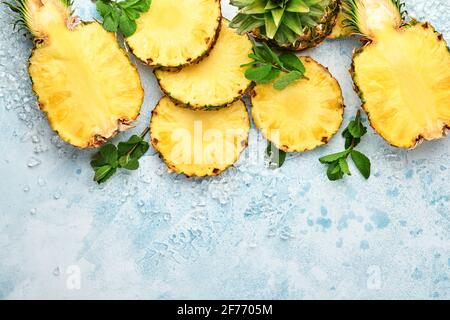 Geschnittene reife Ananas auf hellblauem Stein Hintergrund. Tropische Früchte. Draufsicht. Freier Speicherplatz für Text. Modell. Stockfoto