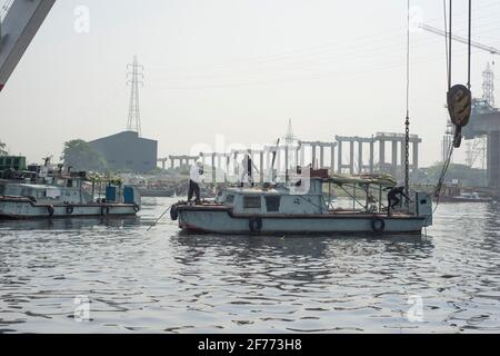 Ein Rettungsteam sah, wie es versuchte, ein gekendertes Boot am Shitalakshya River wiederzuerlangen.EINE Fähre aus Bangladesch kenterte, nachdem sie am Sonntag im Shitalakkhya River südlich der Hauptstadt Dhaka mit einem Frachtschiff kollidierte, wobei mindestens 26 Menschen starben und einige noch vermisst wurden. Stockfoto