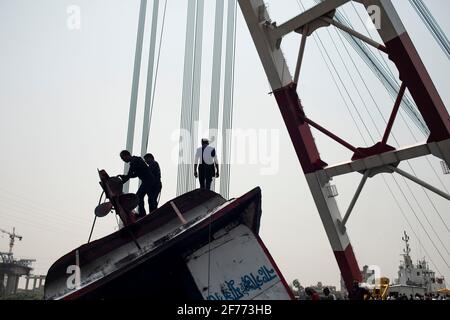 Ein Rettungsteam sah, wie es versuchte, ein gekendertes Boot am Shitalakshya River wiederzuerlangen.EINE Fähre aus Bangladesch kenterte, nachdem sie am Sonntag im Shitalakkhya River südlich der Hauptstadt Dhaka mit einem Frachtschiff kollidierte, wobei mindestens 26 Menschen starben und einige noch vermisst wurden. Stockfoto