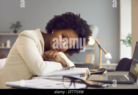 Porträt einer erfolgreichen jungen Geschäftsfrau, die am Schreibtisch sitzt und Blick auf die Kamera Stockfoto