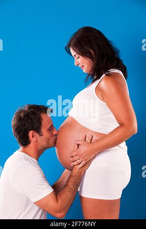 Ehemann küsst den Bauch ihrer Schwangeren Stockfoto