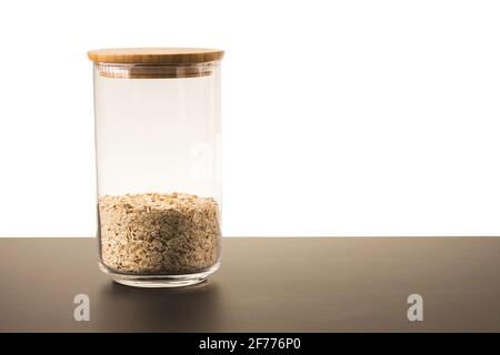 Nahaufnahme des Glasgefäßes mit isoliertem Hafer aus Getreide auf weißem Hintergrund. Küche und gesunde Ernährung Konzept . Stockfoto
