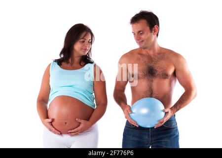 Das Paar hat Spaß mit einer Schwangeren und ihrem Mann Mit einem Ballon auf dem Bauch Stockfoto