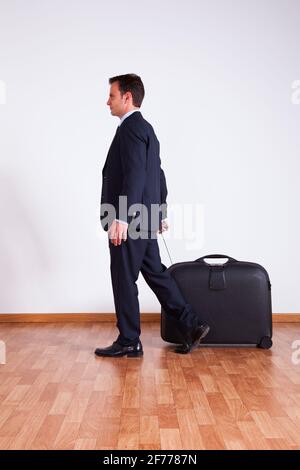 Geschäftsmann ziehen sein Gepäck Stockfoto