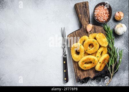 Frittierter knuspriger Tintenfisch und Zwiebelringe paniert. Weißer Hintergrund. Draufsicht. Speicherplatz kopieren Stockfoto