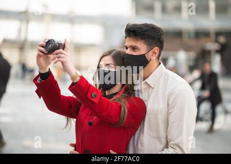 Ein junges Paar von Touristen, die während einer Stadt Fotos machen Covid- oder Coronavirus-Pandemie Stockfoto