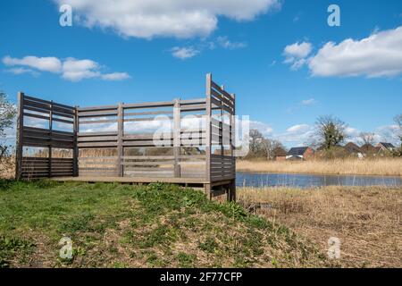 Edenbrook Country Park in Fleet, Hampshire, England, Großbritannien. Ein Vogel versteckt oder Bildschirm mit Blick auf einen Teich. Stockfoto