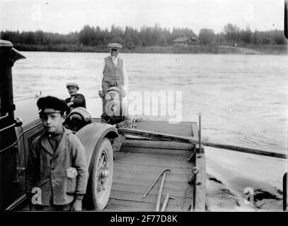 Carl Richard Nyberg, genannt Flight-Nyberg (auf der Rückseite des Bildes), zusammen mit mehreren Personen auf einer Fähre für den Autotransport. Das Bild links an das Technische Museum von Frau Greta Broberg, Stockholm, durch die filmhistorischen Sammlungen Januar 1952. Stockfoto